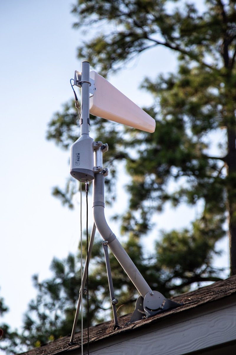 A SOCA rotator on a braced roof mount carrying a log periodic directional antenna, with a single coaxial lead running down from it.