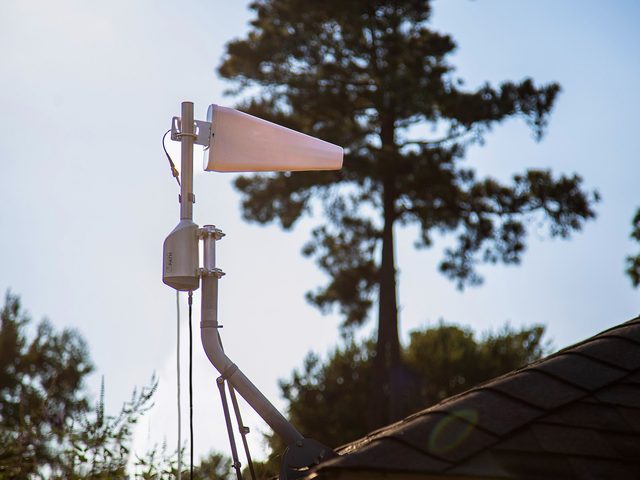A SOCA rotator carrying a log periodic antenna on a roof mast at a house.